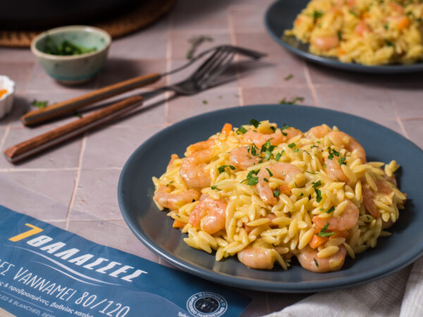 Κριθαρότο με γαρίδες σε μπλε πιάτο, σερβιρισμένο με μυρωδικά.