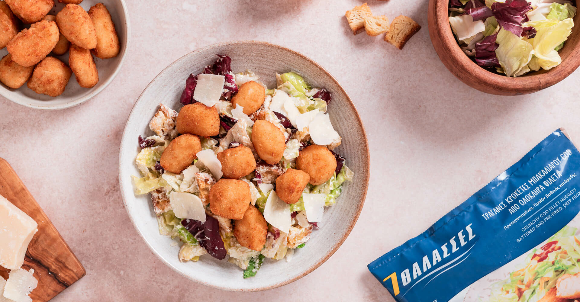 Caesar Salad με Crispy Cod Bites 7 ΘΑΛΑΣΣΕΣ Σαλάτα Caesar με τραγανές μπουκιές μπακαλιάρου 7 ΘΑΛΑΣΣΕΣ, παρμεζάνα και φρέσκα λαχανικά.